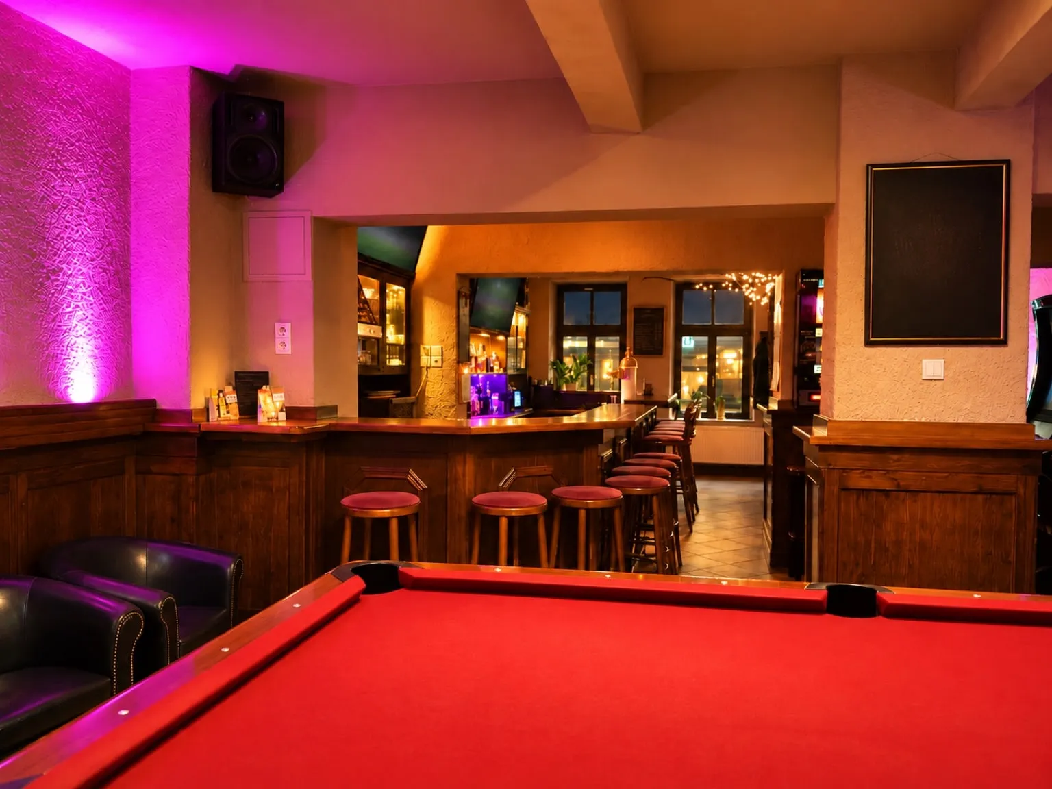 Pool table with red cloth, the bar behind it