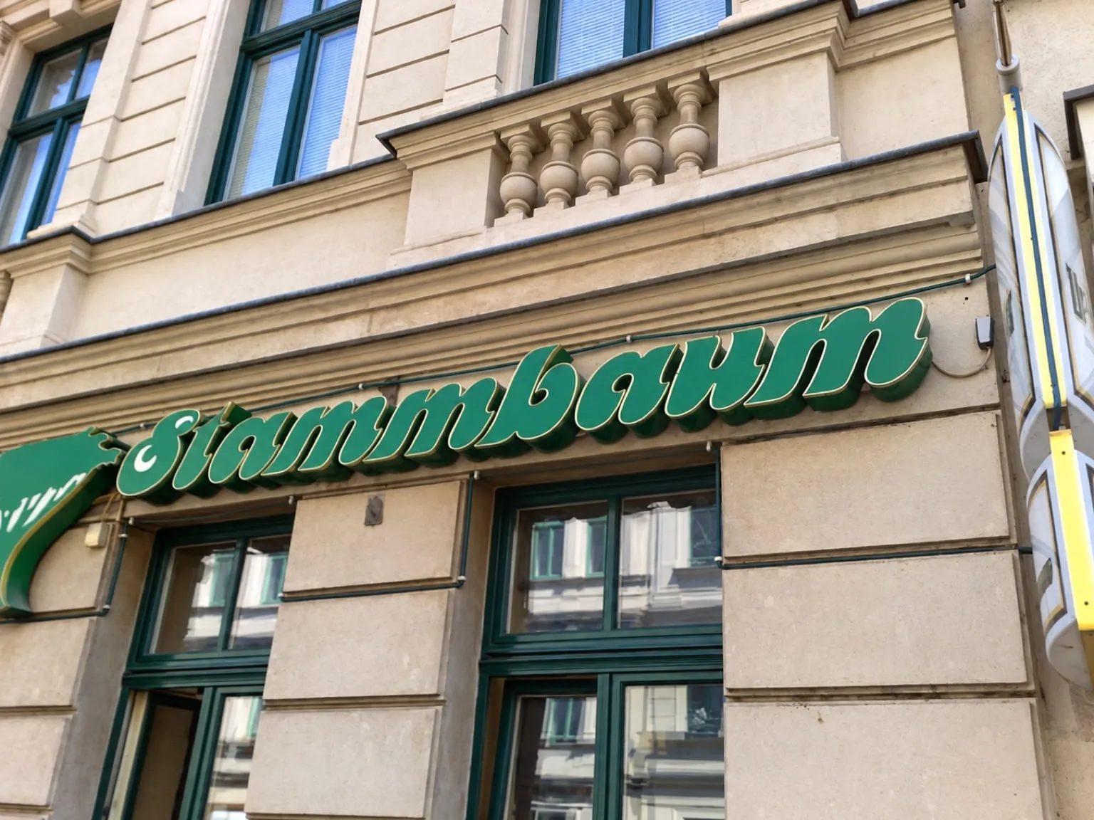 Building front with the green “Zum Stammbaum” lettering