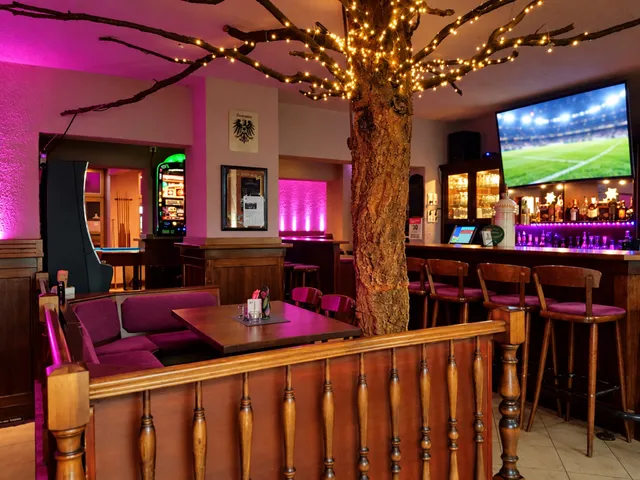 Sports bar with a big TV, tree with fairy lights and the bar